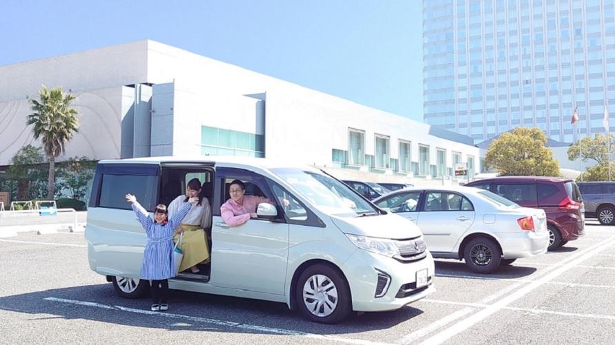 グランドプリンスホテル広島の平面駐車場で家族が乗り降りしている。