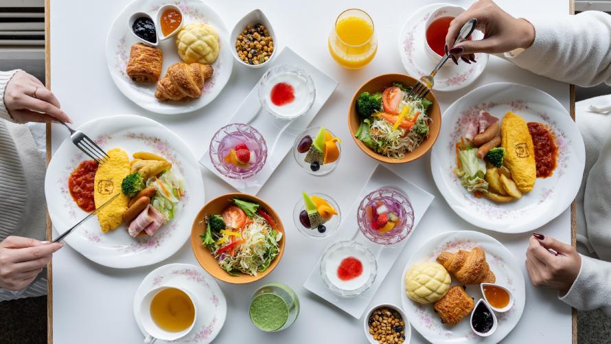 朝食をとる二人。地元食材を取り入れた和洋ブッフェで1日の活力を