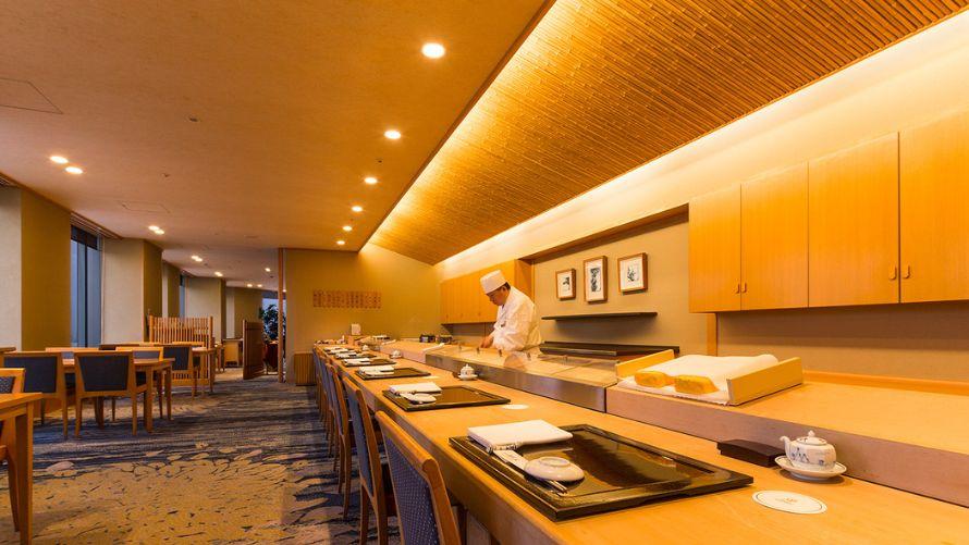 五十三次日本橋店内。カウンター内で板前が料理中。