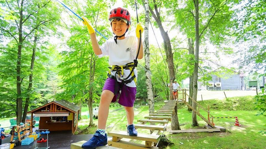 子どもがツリーアドベンチャーを楽しんでいる