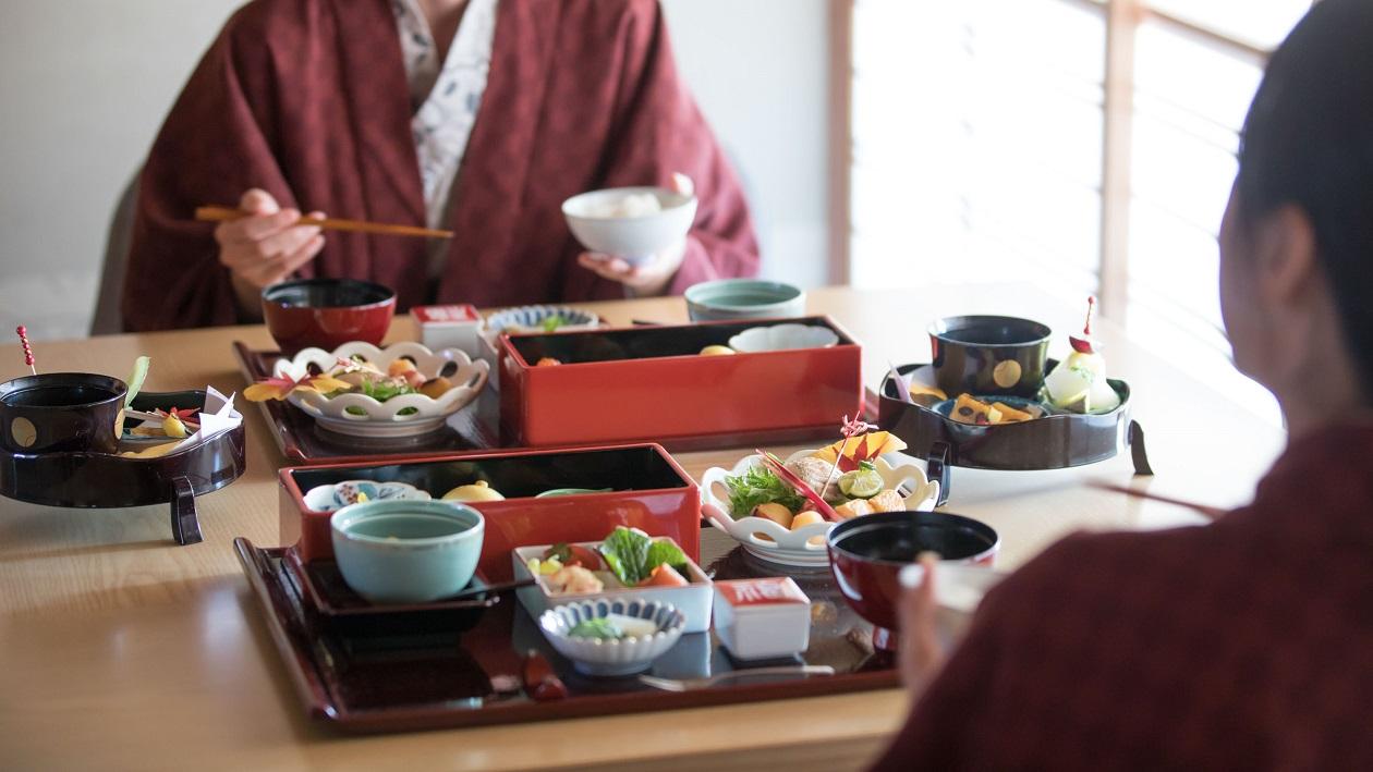 二人の女性が客室で朝食を食べている。