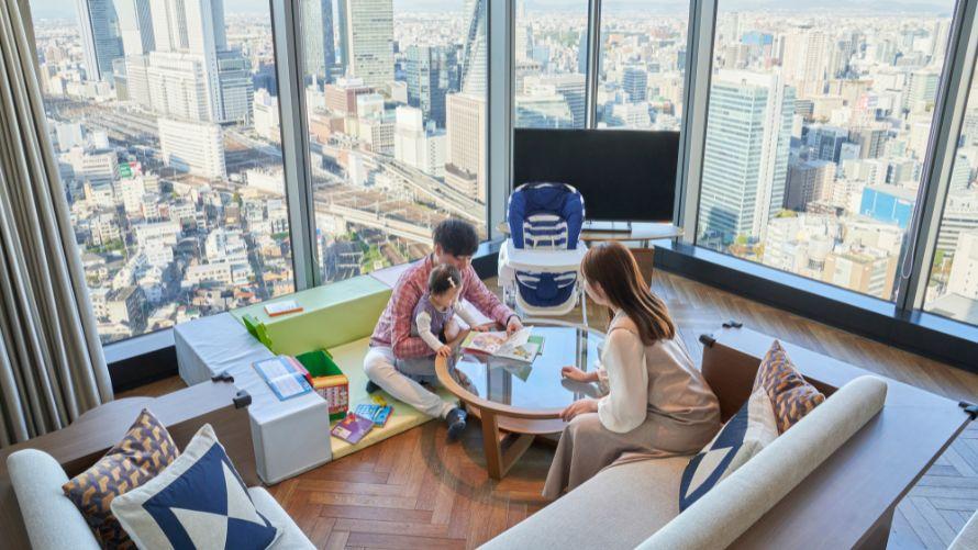 プレイマットの上で子供と両親が遊んでいる