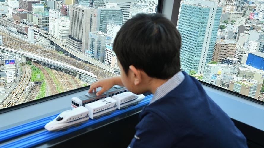 男の子が部屋からのトレインビューとともにプラレールで遊ぶ