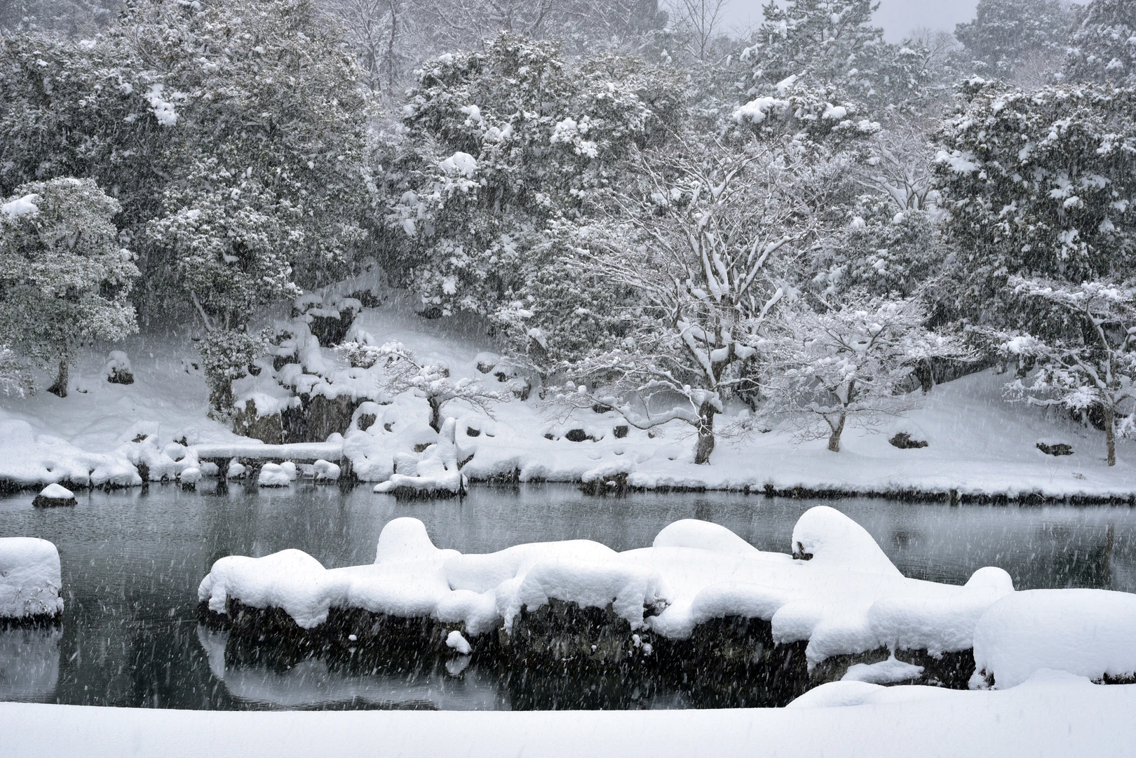 PIXTAより「雪の降る天龍寺 曹源池庭園」