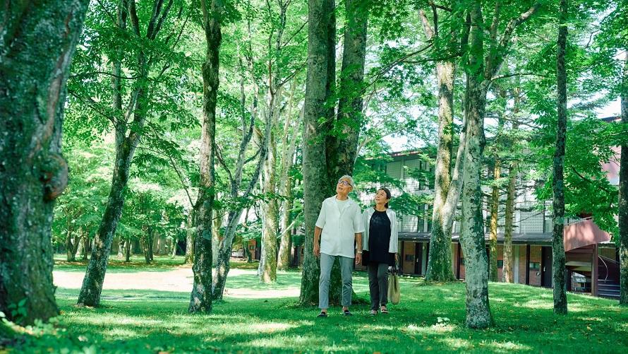 軽井沢の自然の中を散歩するご夫婦。エンジョイチケットで軽井沢を満喫しよう。